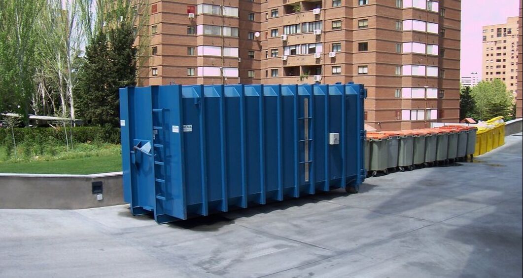 A large roll off dumpster outside an apartment
